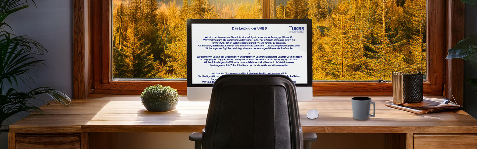 Ein Arbeitsplatz mit Bildschirm, auf dem das UKBS-Leitbild dargestellt wird.