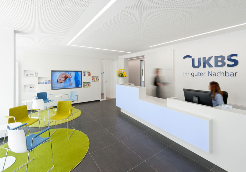 Der UKBS-Empfangsbereich mit zwei Mitarbeitenden.